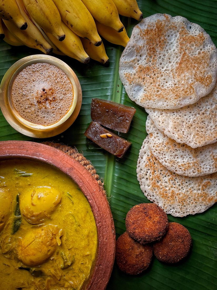 Appam with egg curry on a banana leaf